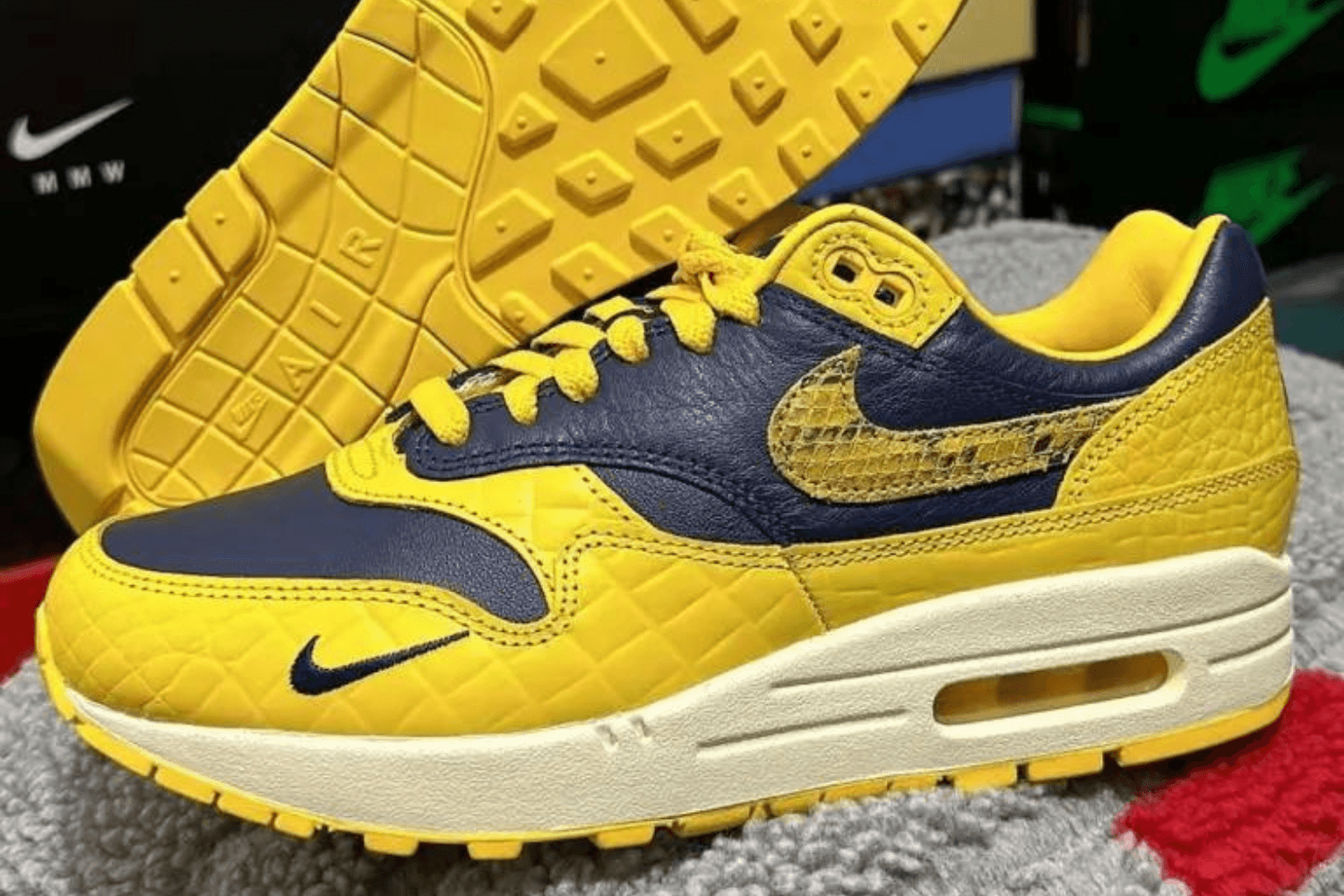 The Nike Air Max 1 PRM appears in a 'Michigan' colorway