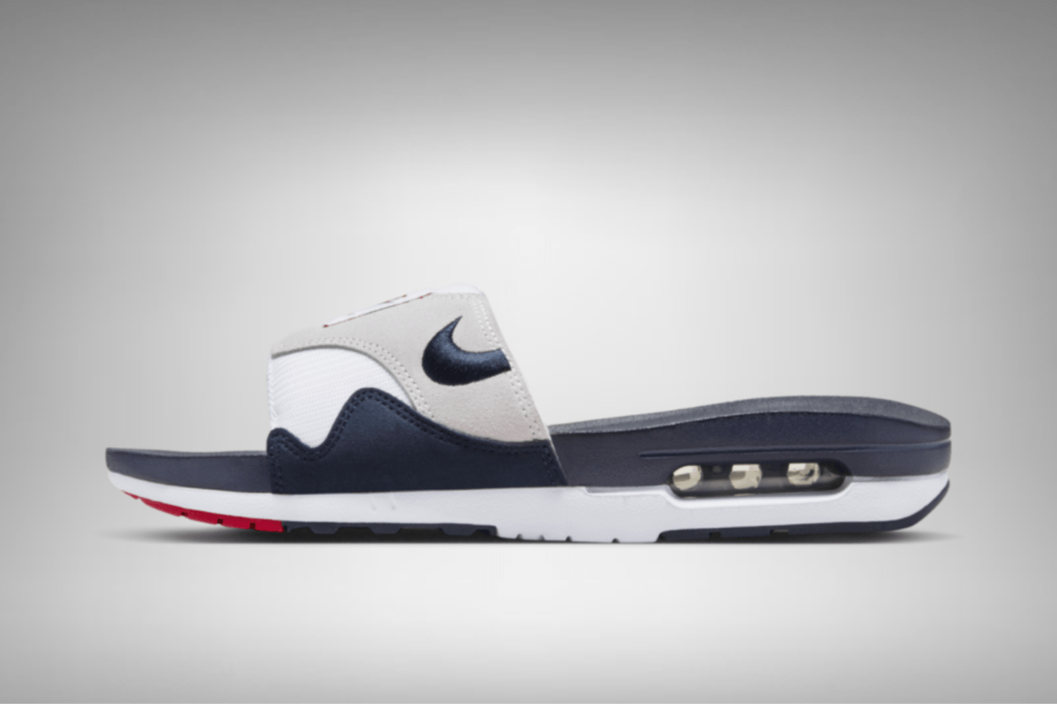 The Nike Air Max 1 Slide appears in an 'Obsidian' colorway