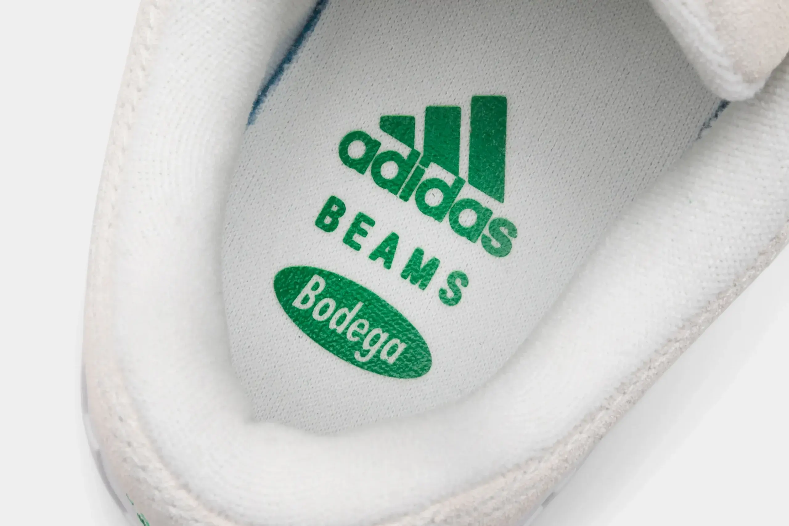 adidas Adimatic Bodega X Beams Off White/ Green/ Crystal White. detail shot met groen adidas logo, BEAMS logo en Bodega logo